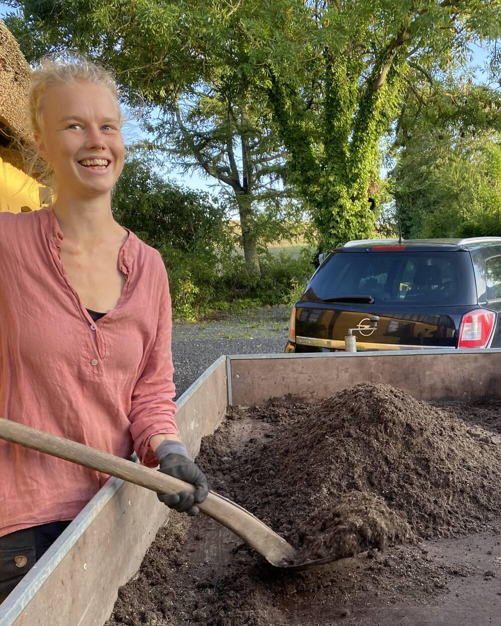 Jeg skovler jord af traileren i arbejdstøj